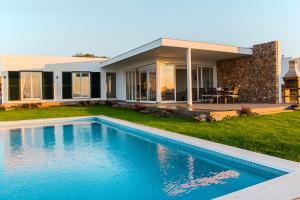 a house with a swimming pool in front of it at Villa Bella in Es Mercadal