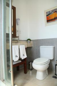 a bathroom with a toilet and a sink with towels at Ribera Sur Hotel Mar del Plata in Mar del Plata