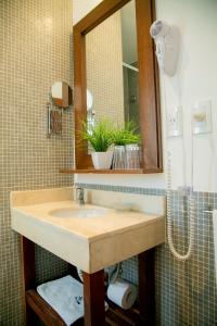 een badkamer met een wastafel en een spiegel bij Ribera Sur Hotel Mar del Plata in Mar del Plata