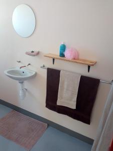 y baño con lavabo, espejo y toallas. en Stop 'n Stay Otavi Rest Camp, en Otavi