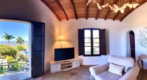 a living room with a tv and a chair and a window at Monte Borboleta in Faro