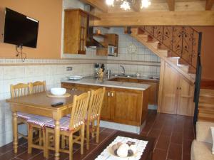 una cocina con mesa, lavabo y escalera en Apartamentos Rurales Posada de las Hoces en Bustiello de Paredes