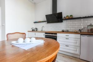 cocina con mesa de madera y electrodomésticos blancos en SunHouse Apartment, en Toruń