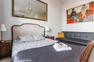 Un dormitorio con una cama, un sofá y un espejo. en SunHouse Apartment, en Toruń