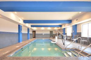 a swimming pool in a hotel with blue ceilings at Holiday Inn Express & Suites Oklahoma City Mid - Arpt Area, an IHG Hotel in Oklahoma City