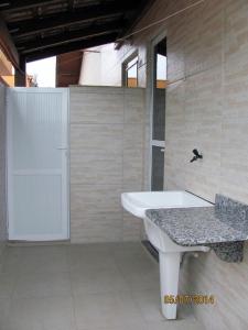 a bathroom with a sink and a bath tub at Duplex com vista do mar! in Itapema
