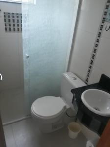 a bathroom with a white toilet and a sink at Duplex com vista do mar! in Itapema