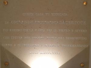 een bord op een muur met een tekst erop bij B&B L'ABBAZIA in Torre Maggiore