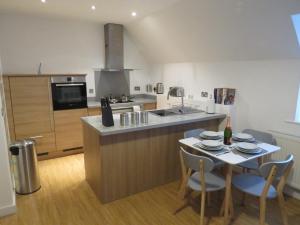 a kitchen with a table with chairs and a counter top at Hamilton Apartment in Doncaster