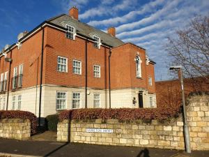 ein großes rotes Backsteingebäude mit einer Ziegelwand in der Unterkunft Hamilton Apartment in Doncaster