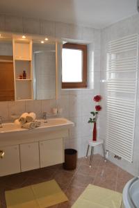 a bathroom with a sink and a vase with a flower at Ferienwohnungen Andreas Hofer in Tux