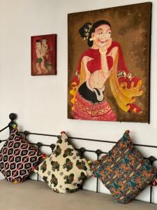 a room with pillows and a painting on the wall at See You Soon, Chiang Mai in Chiang Mai