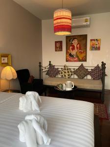 a bedroom with a bed with towels on it at See You Soon, Chiang Mai in Chiang Mai