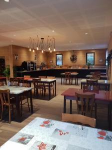 ein Speisesaal mit Tischen und Stühlen und ein Restaurant in der Unterkunft Hôtel Le Picors in Aucun