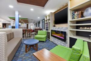 a living room with a couch and chairs and a fireplace at Holiday Inn Express Winnipeg Airport - Polo Park, an IHG Hotel in Winnipeg