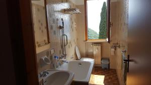 a bathroom with a sink and a tub and a toilet at LA PERLA DEL CENTRO LAGO DI COMO in Perledo +35 photos