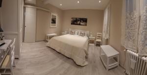 una camera con un letto bianco e due tavoli di Reggiolacittàinvisibile B&B a Reggio Emilia