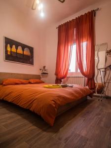 a bedroom with a bed with red curtains and a window at A cà da Susi in La Spezia