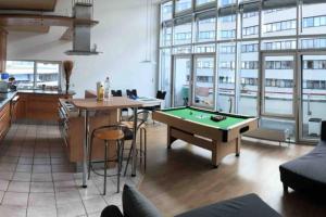 a living room with a pool table and a kitchen at Premium Penthouse Wohnung mit Schlossblick Zentral in Heidenheim mit Tiefgarage in Heidenheim