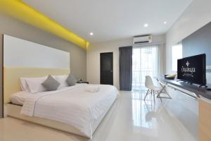 1 dormitorio con 1 cama y TV de pantalla plana en Baan Lamoon en Ratchaburi