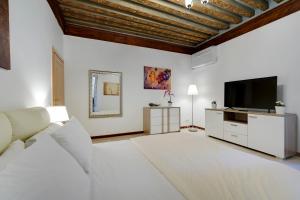 een woonkamer met een bank en een flatscreen-tv bij Ca' Rialto in Venetië