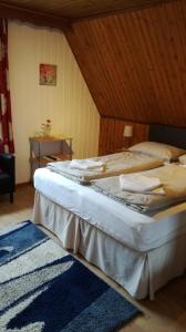 a bedroom with two beds and a rug at Pension Julia in Feld am See