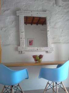 two blue chairs and a mirror on a table at Sea Side Studios & Houses in Kalo Livadi