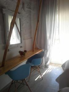 a desk in a room with two blue chairs and a window at Sea Side Studios & Houses in Kalo Livadi