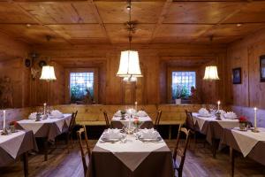 uma sala de jantar com mesas e cadeiras com luzes em Charme Hotel Uridl em Santa Cristina in Val Gardena