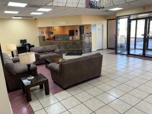 a waiting room with couches and tables in a lobby at Travelodge by Wyndham Odessa in Odessa