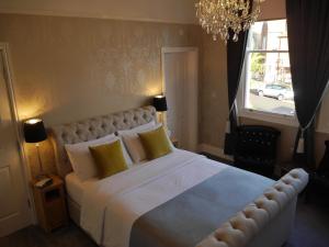 a bedroom with a large white bed with yellow pillows at Haversham House - Adults Only in Llandudno