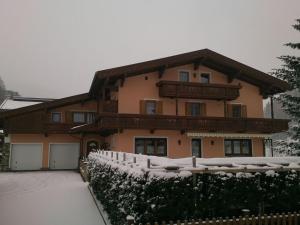 a house with a snow covered fence in front of it at Ferienwohnungen Andreas Hofer in Tux