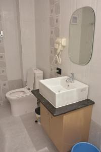 ein Badezimmer mit einem Waschbecken, einem WC und einem Spiegel in der Unterkunft Island Cliff in Port Blair