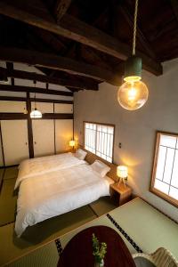 a bedroom with a large bed and two windows at Ebisuya / Vacation STAY 5850 in Kofu