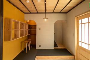 Cette chambre est dotée de murs jaunes et de plafonds en bois. dans l'établissement Ebisuya / Vacation STAY 5850, à Kōfu