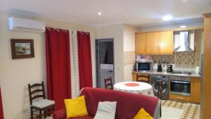 a living room with a red couch and a kitchen at Private Apartament Celestina & Carlos in Mindelo