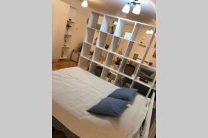 Zimmer mit einem Bett und einem Regal mit blauen Kissen in der Unterkunft Apartman Iva in Belgrad