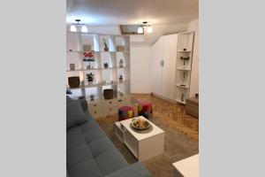ein Wohnzimmer mit einem Sofa und einem Tisch in der Unterkunft Apartman Iva in Belgrad
