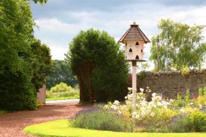 a bird house in the middle of a garden at The Old Parsonage Country House in Berwick-Upon-Tweed