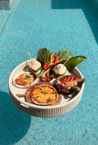 a tray of food on a table next to a pool at House Of Passion Amphawa in Amphawa