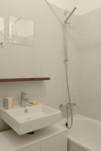 a white bathroom with a sink and a shower at Entrecampos 6 in Lisbon