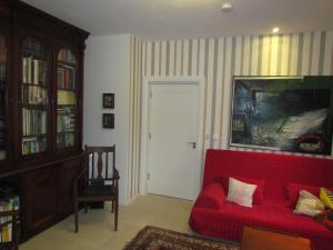 a living room with a red couch and a door at Romantic Hideaway in Goleen