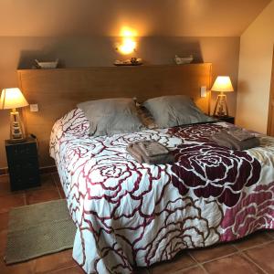 ein großes Bett in einem Schlafzimmer mit zwei Lampen in der Unterkunft Gîte les Prairies in Maresches