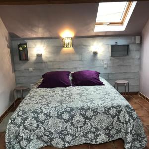 1 dormitorio con 1 cama grande con almohadas moradas en Gîte les Prairies, en Maresches