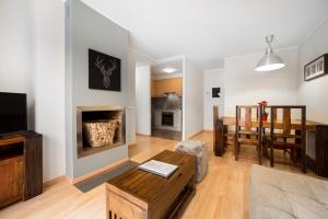 a living room with a fireplace and a dining room at Apartaments El Floc in El Tarter