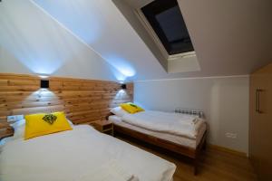 a bedroom with two beds and a skylight at Apartamenty Słoneczny Przystanek in Szczyrk