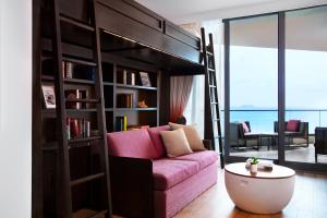 a living room with a bunk bed with a pink couch at Kimpton Seafire Resort + Spa by IHG in West Bay