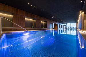 a large swimming pool with blue water in a building at Mountain Residence Montana in Santa Maddalena