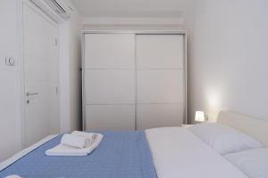 ein weißes Schlafzimmer mit einem Bett mit Handtüchern darauf in der Unterkunft Trebinje Star in Trebinje