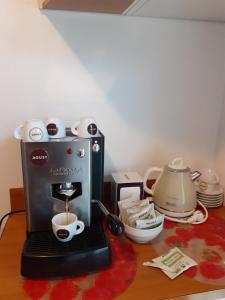 a coffee maker sitting on a table with a cup of coffee at appartamenti vacanza El Remanso in Edolo +4 photos